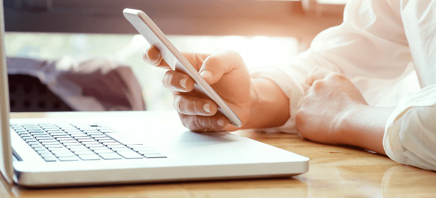 Businessman using laptop and mobile phone