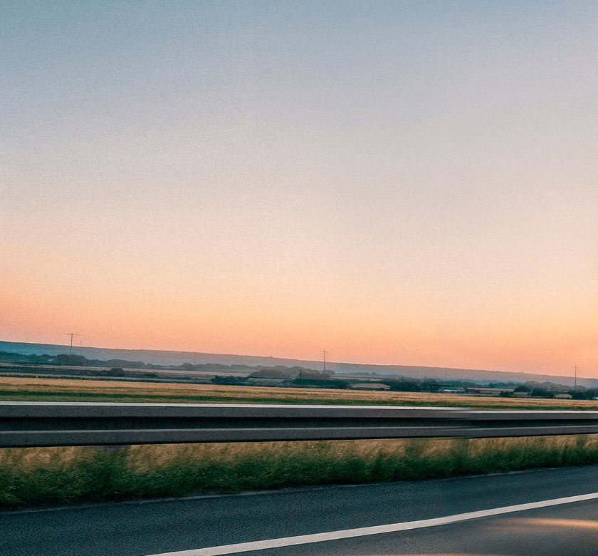 Red delivery truck on highway at sunset