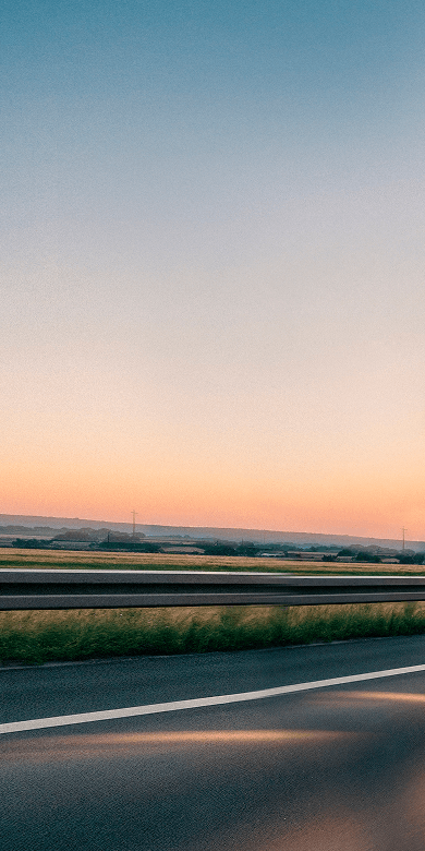 Red delivery truck on highway at sunset