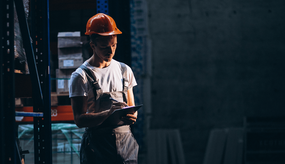 Young man working in warehouse with boxes